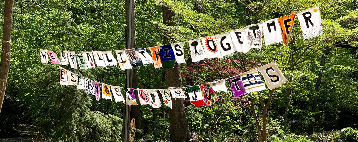 "we are all in this together" spelled on cloths along a clothes line